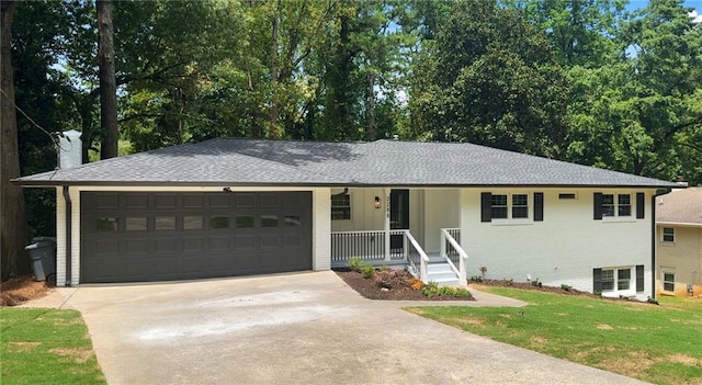 view of front of home featuring a front lawn, covered porch, and a garage