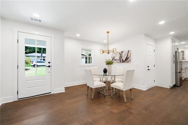 dining area with a notable chandelier and dark hardwood / wood-style floors