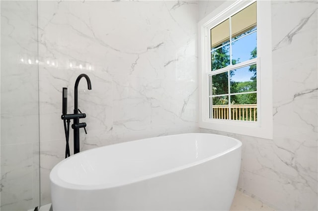 bathroom with tile walls and a tub to relax in