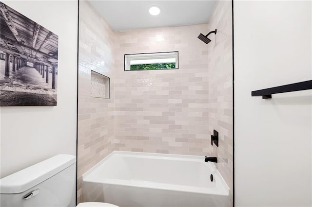 bathroom with tiled shower / bath and toilet