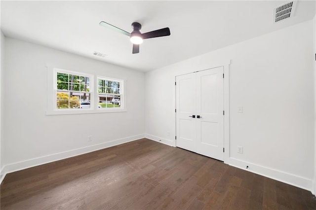 unfurnished bedroom with dark hardwood / wood-style floors, a closet, and ceiling fan