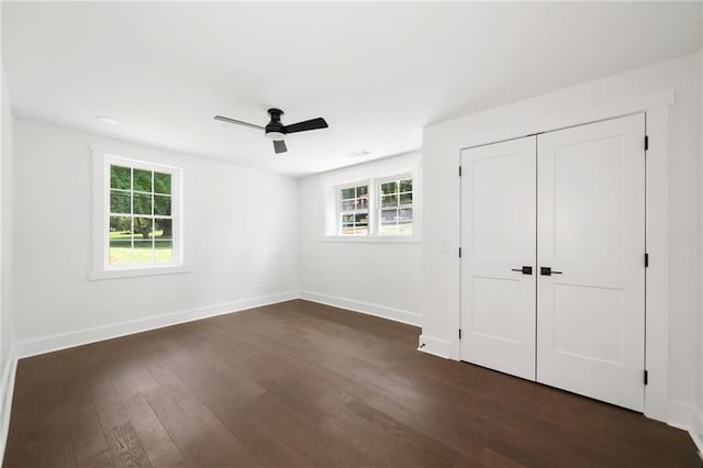 unfurnished bedroom with ceiling fan, dark hardwood / wood-style flooring, and a closet