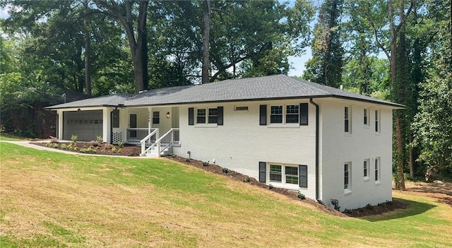 exterior space featuring covered porch, a front yard, and a garage