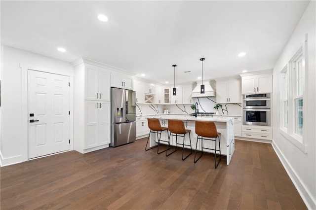 kitchen with appliances with stainless steel finishes, custom exhaust hood, a kitchen island, and dark wood-type flooring