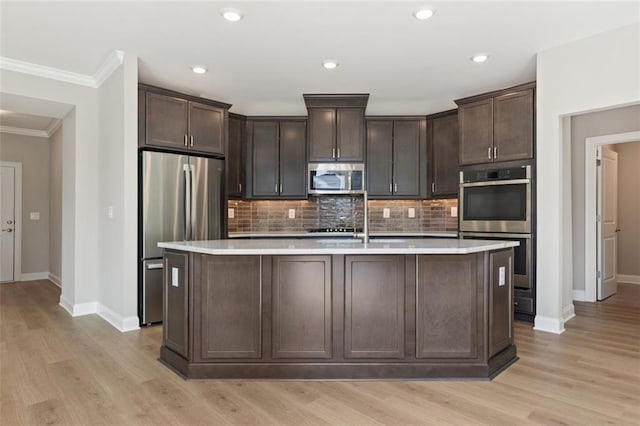 kitchen featuring dark brown cabinetry, stainless steel appliances, baseboards, and ornamental molding