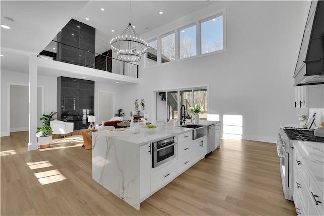 kitchen featuring white cabinetry, stainless steel appliances, a high ceiling, and sink