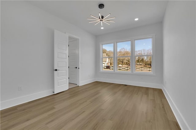 unfurnished bedroom with a notable chandelier and light hardwood / wood-style floors