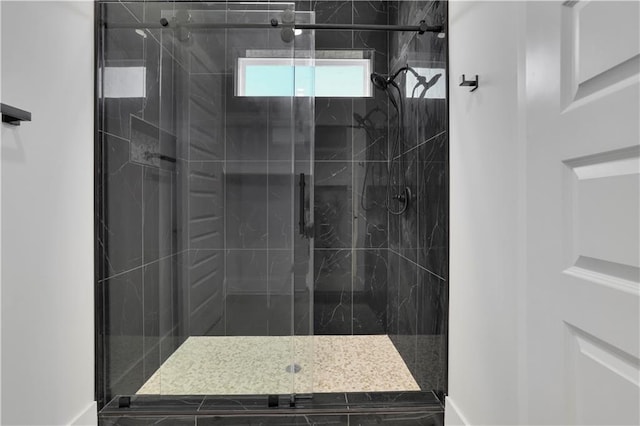 bathroom with a shower with door