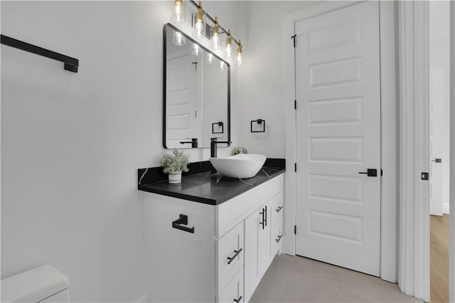 bathroom with toilet, tile patterned floors, and vanity