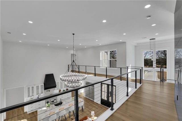 hall with a notable chandelier and hardwood / wood-style flooring