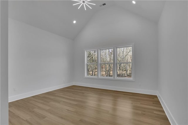 empty room featuring high vaulted ceiling and light hardwood / wood-style flooring