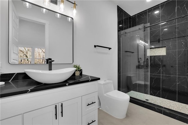 bathroom featuring toilet, vanity, and a tile shower