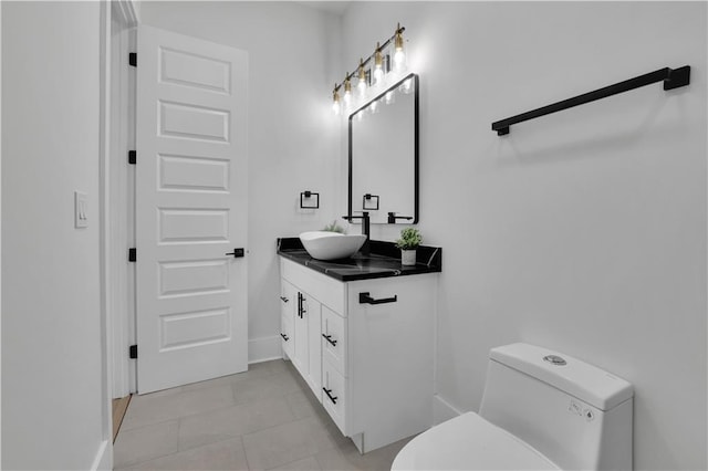 bathroom with toilet, vanity, and tile patterned floors