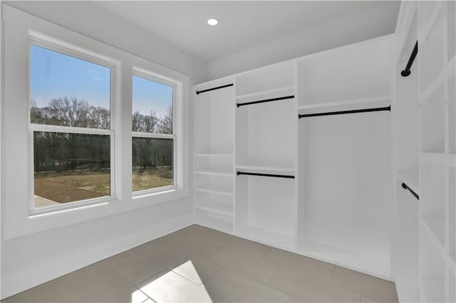 walk in closet with light tile patterned floors