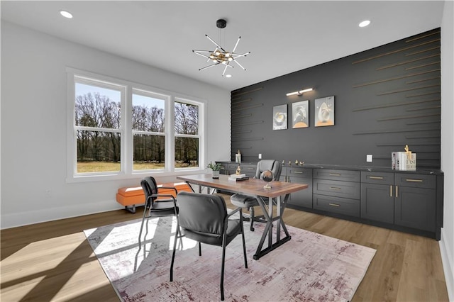 dining area with a notable chandelier and light hardwood / wood-style flooring