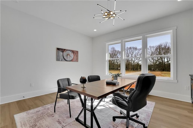 office space with light hardwood / wood-style flooring and a notable chandelier