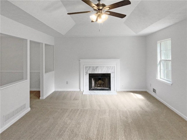 unfurnished living room featuring ceiling fan, light colored carpet, and a fireplace