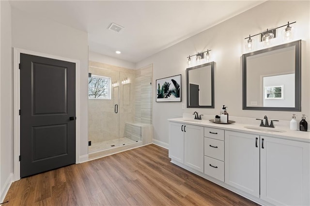 bathroom featuring hardwood / wood-style floors, vanity, and a shower with door