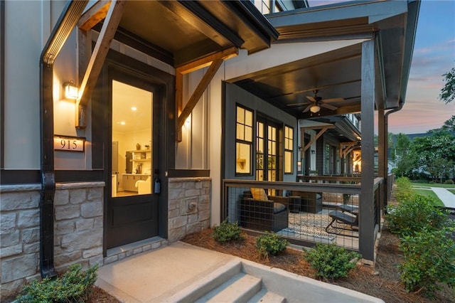 exterior entry at dusk with ceiling fan and a porch