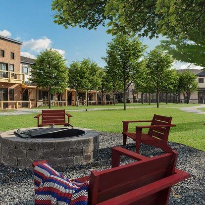 view of property's community with a lawn and a fire pit