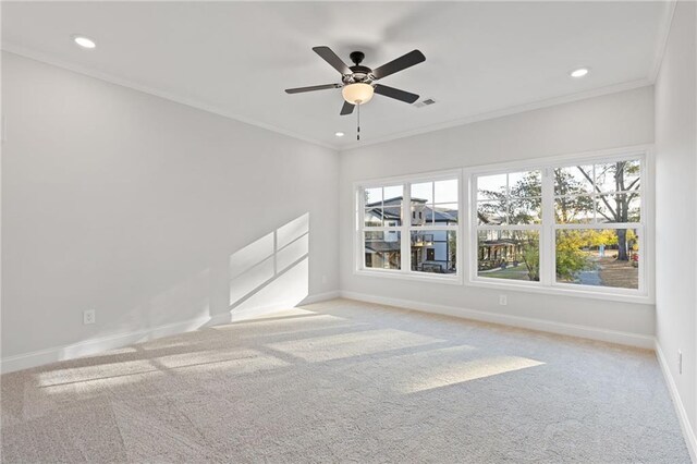 carpeted spare room with ceiling fan and ornamental molding