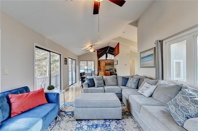 living room featuring ceiling fan, light wood-type flooring, and vaulted ceiling