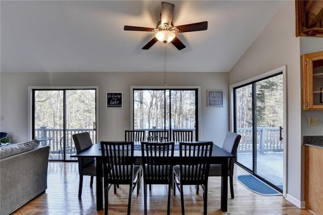 dining room with light wood-style floors, ceiling fan, and lofted ceiling