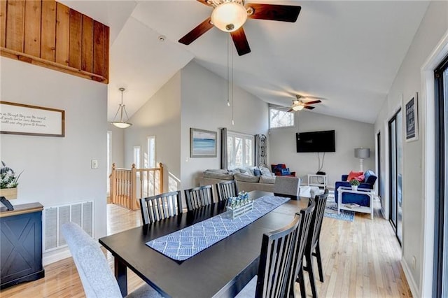 dining area featuring a ceiling fan, light wood-style flooring, and vaulted ceiling