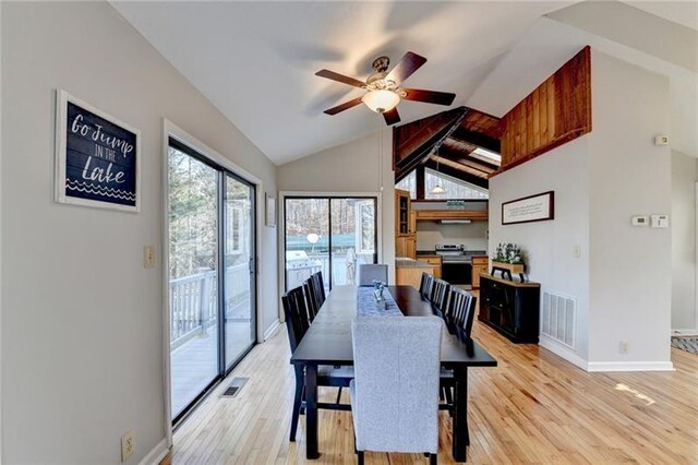 dining space with a ceiling fan, light wood finished floors, baseboards, and high vaulted ceiling