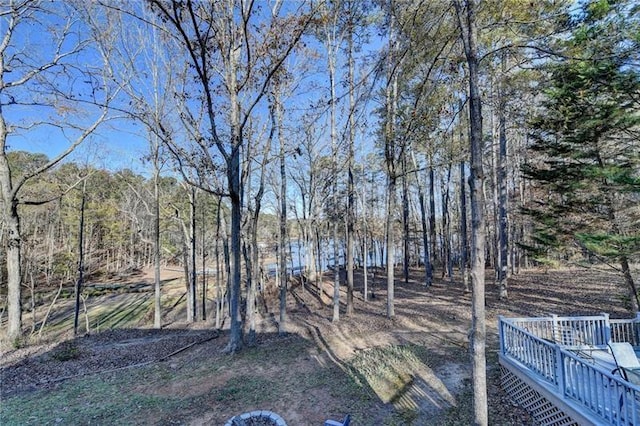 view of yard featuring a deck and a view of trees