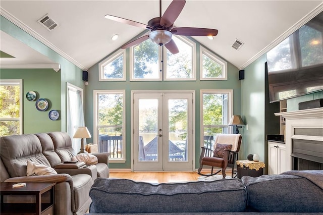 living room featuring lofted ceiling, french doors, crown molding, and light wood-type flooring