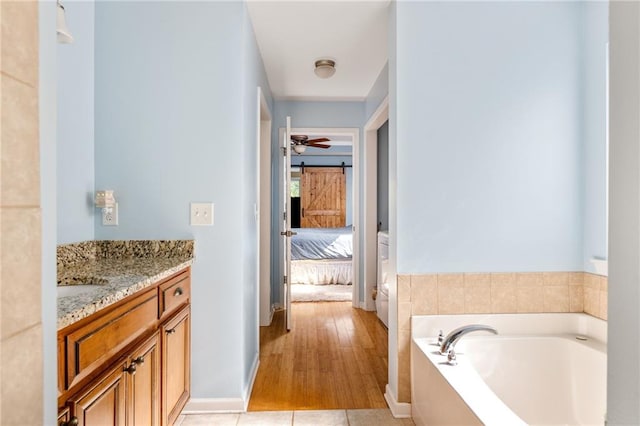 bathroom with a bath, hardwood / wood-style floors, and vanity