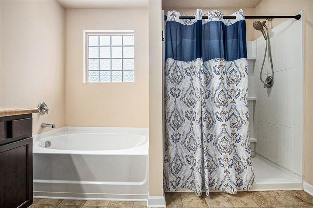 full bathroom with baseboards, a bath, and a stall shower