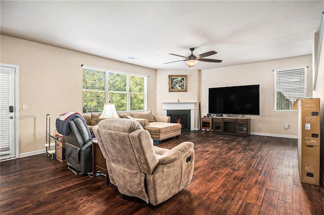 living area featuring visible vents, dark wood-style flooring, a fireplace, baseboards, and a ceiling fan