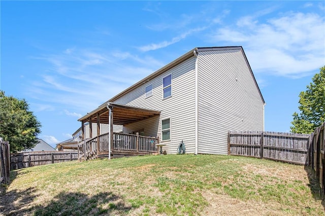 rear view of house featuring a fenced backyard, a wooden deck, and a yard