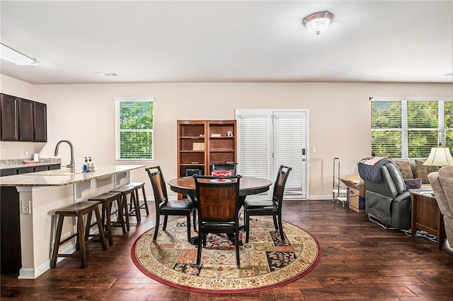 dining space with a healthy amount of sunlight, baseboards, and dark wood-style flooring