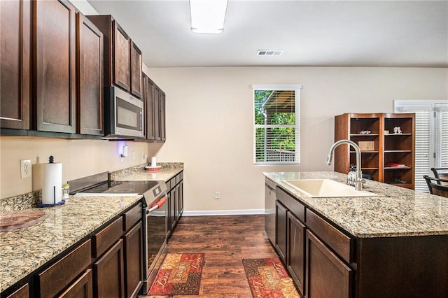 kitchen with visible vents, dark brown cabinets, a sink, dark wood finished floors, and stainless steel appliances