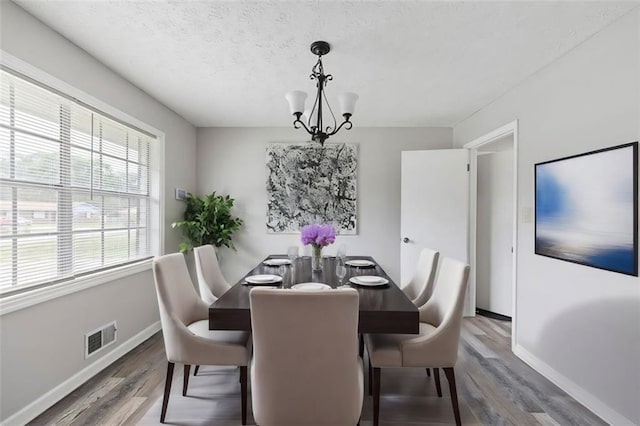 2103 Blue Creek Ct, Conley, GA 30288 - dining space featuring a chandelier, wood finished floors, and a textured ceiling