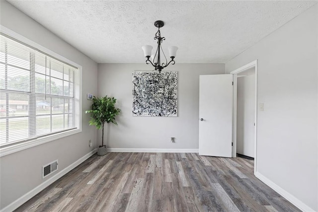 2103 Blue Creek Ct, Conley, GA 30288 - unfurnished dining area with a chandelier, wood finished floors, and a textured ceiling