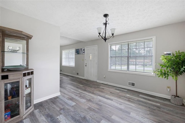 2103 Blue Creek Ct, Conley, GA 30288 - unfurnished living room with a chandelier, wood finished floors, and a textured ceiling