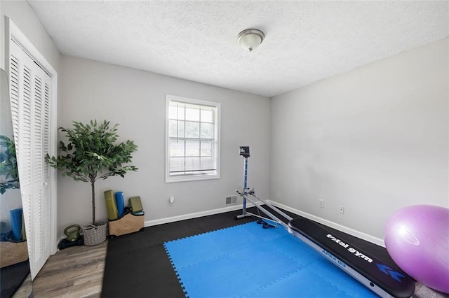 2103 Blue Creek Ct, Conley, GA 30288 - exercise room featuring a textured ceiling and wood finished floors