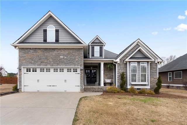 traditional-style home featuring stone siding, a front lawn, and driveway