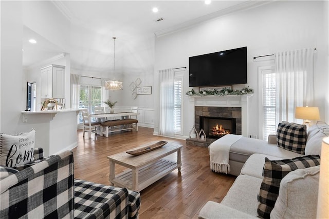 living area featuring hardwood / wood-style floors, visible vents, and ornamental molding