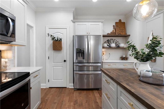 kitchen with dark wood-type flooring, backsplash, stainless steel appliances, crown molding, and wooden counters