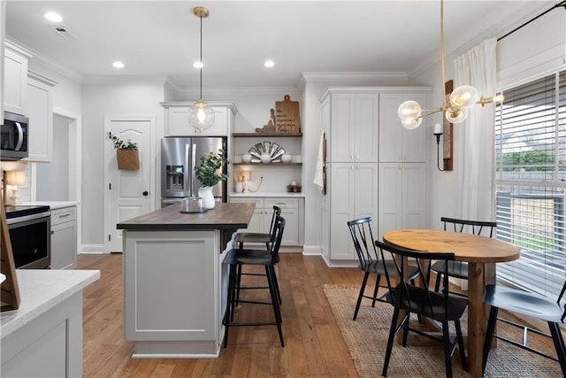 kitchen with visible vents, plenty of natural light, stainless steel appliances, and crown molding