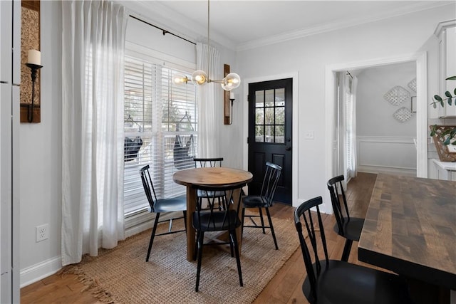 dining area featuring a chandelier, crown molding, and light wood-type flooring