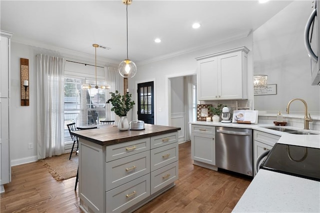 kitchen featuring a sink, butcher block countertops, dishwasher, and a chandelier