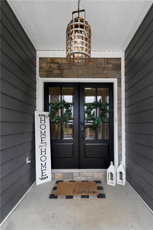 doorway to property featuring french doors and stone siding