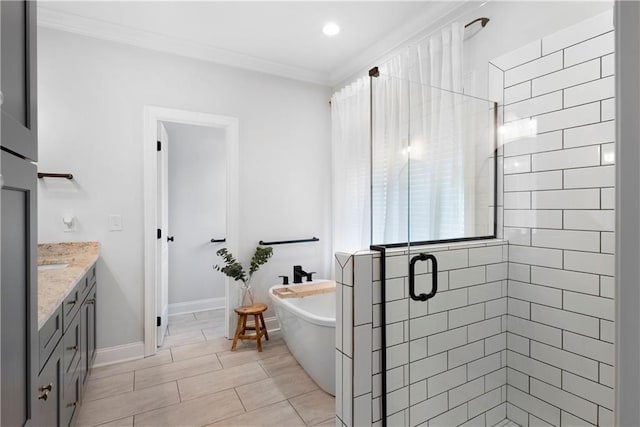 full bath with vanity, baseboards, a freestanding tub, a stall shower, and crown molding