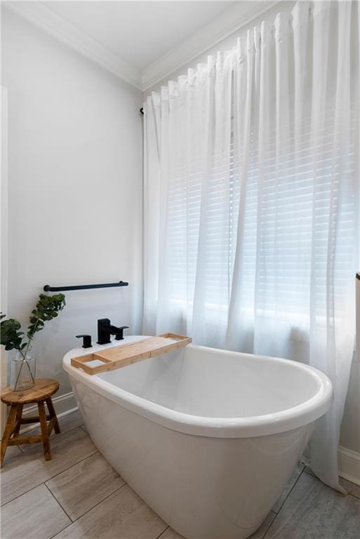 full bath with a soaking tub and ornamental molding